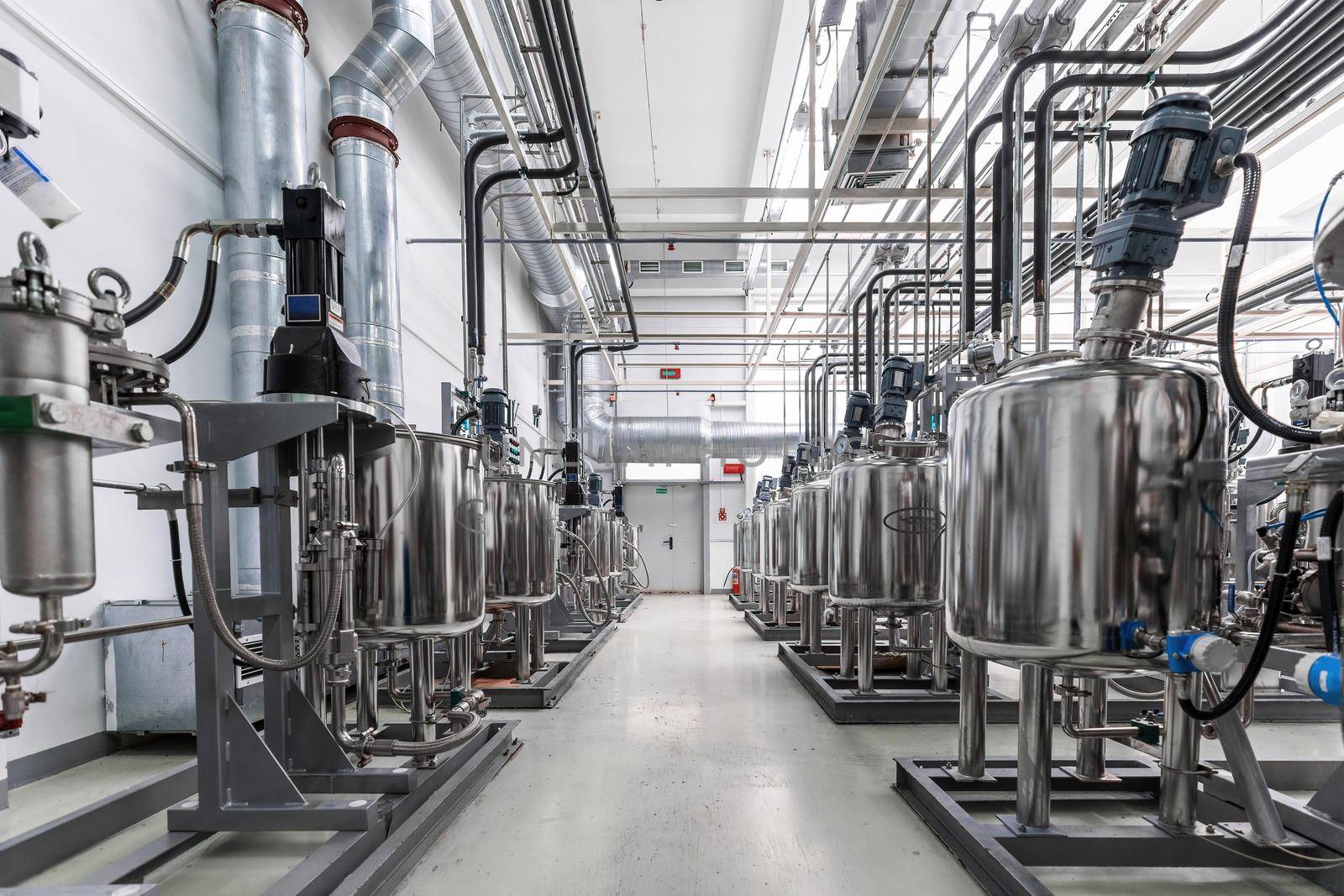 Photo of gray pipes and tanks. Chemistry and medicine production. Pharmaceutical factory. Interior of a high-tech factory, modern production.