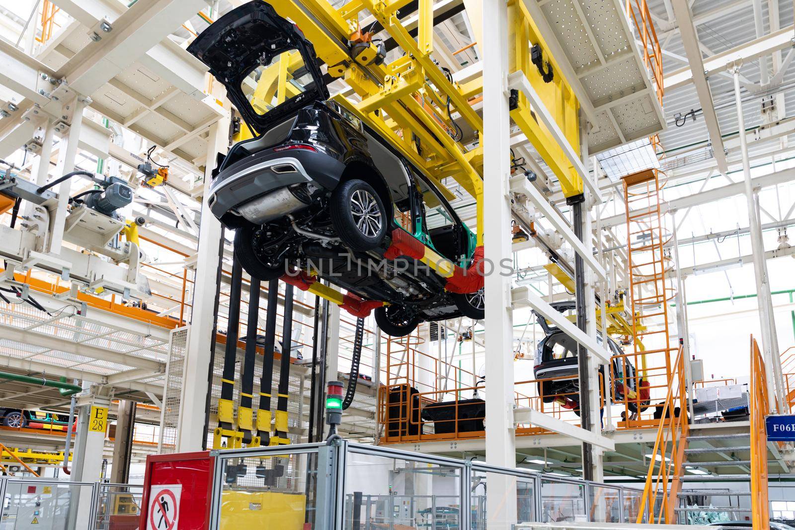 Photo of automobile production line. Welding car body. Modern car assembly plant. Auto industry. Interior of a high-tech factory.