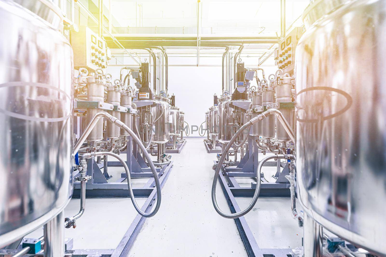 Photo of pipes and tanks. Chemistry and medicine production. Pharmaceutical factory. Interior of a high-tech plant, modern production. Yellow tone.