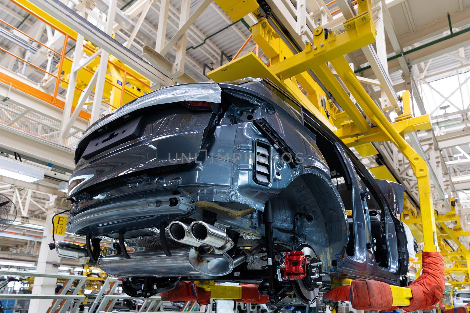 Photo of automobile production line. Welding car body. Modern car assembly plant. Auto industry. Interior of a high-tech factory.
