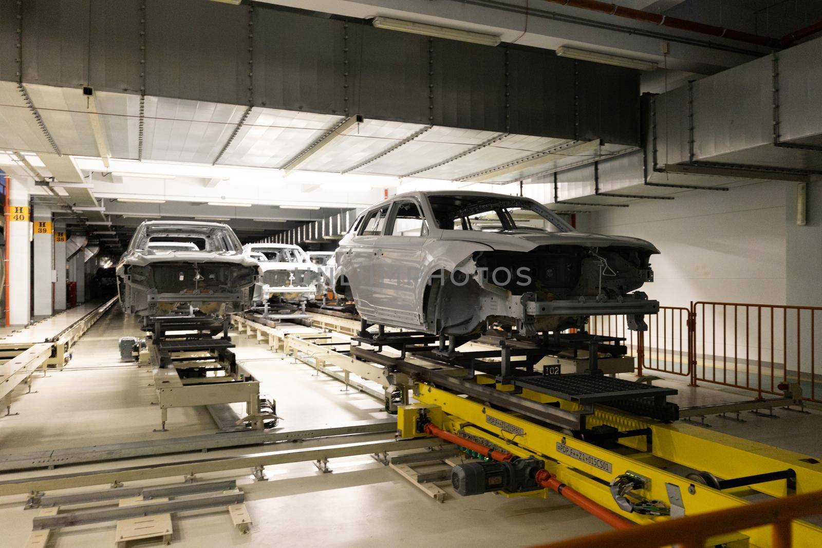 Car bodies are on assembly line. Modern automotive industry. Automobile conveyor. Interior of factory of manufacturing and production.