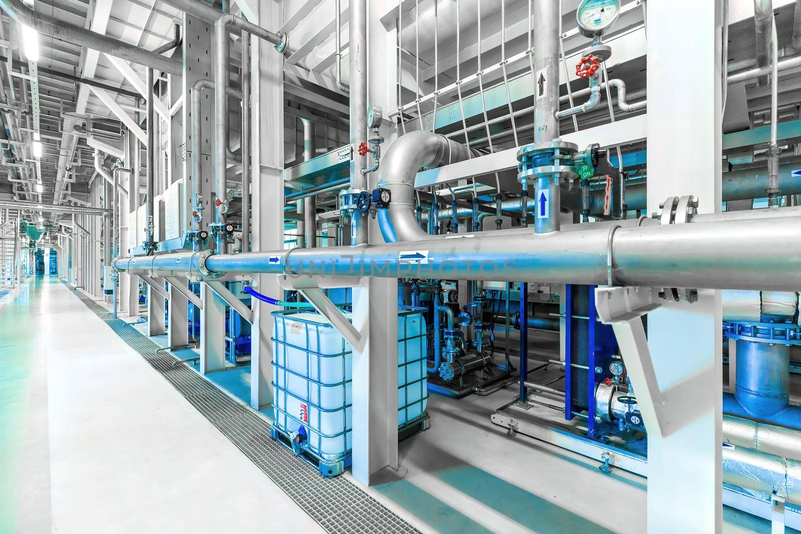 Photo of pipes and tanks. Chemistry and medicine production. Pharmaceutical factory. Interior of a high-tech factory, modern production. Blue tone.