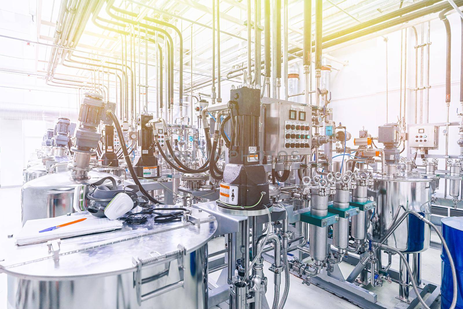 Photo of pipes and tanks. Chemistry and medicine production. Pharmaceutical factory. Interior of a high-tech factory, modern production, Yellow light tone.