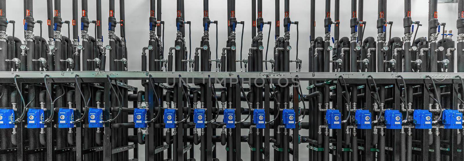 Panoramic photo of production pumps on the wall in a modern factory. Chemistry and medicine production. Pharmaceutical high-tech plant interior.