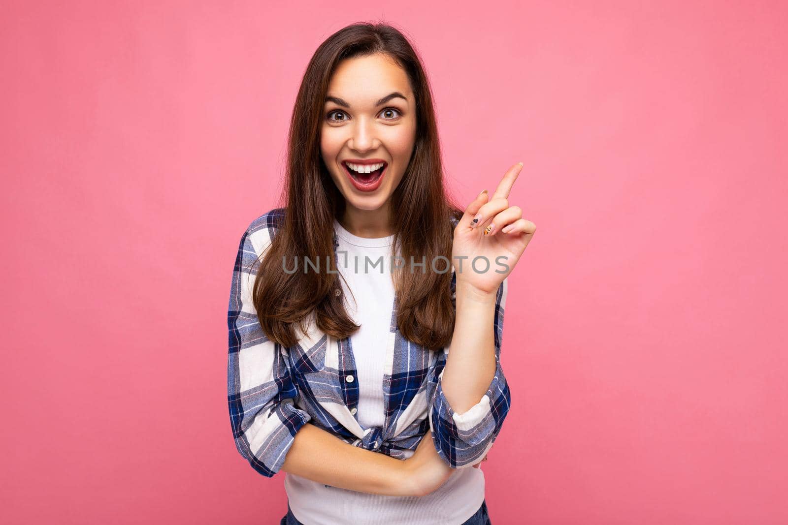 Photo portrait of young beautiful shocked, amazed shocked brunette woman in trendy blue and white shirt. Female person posing isolated near pink wall with empty space in studio. Positive model having an idea by TRMK