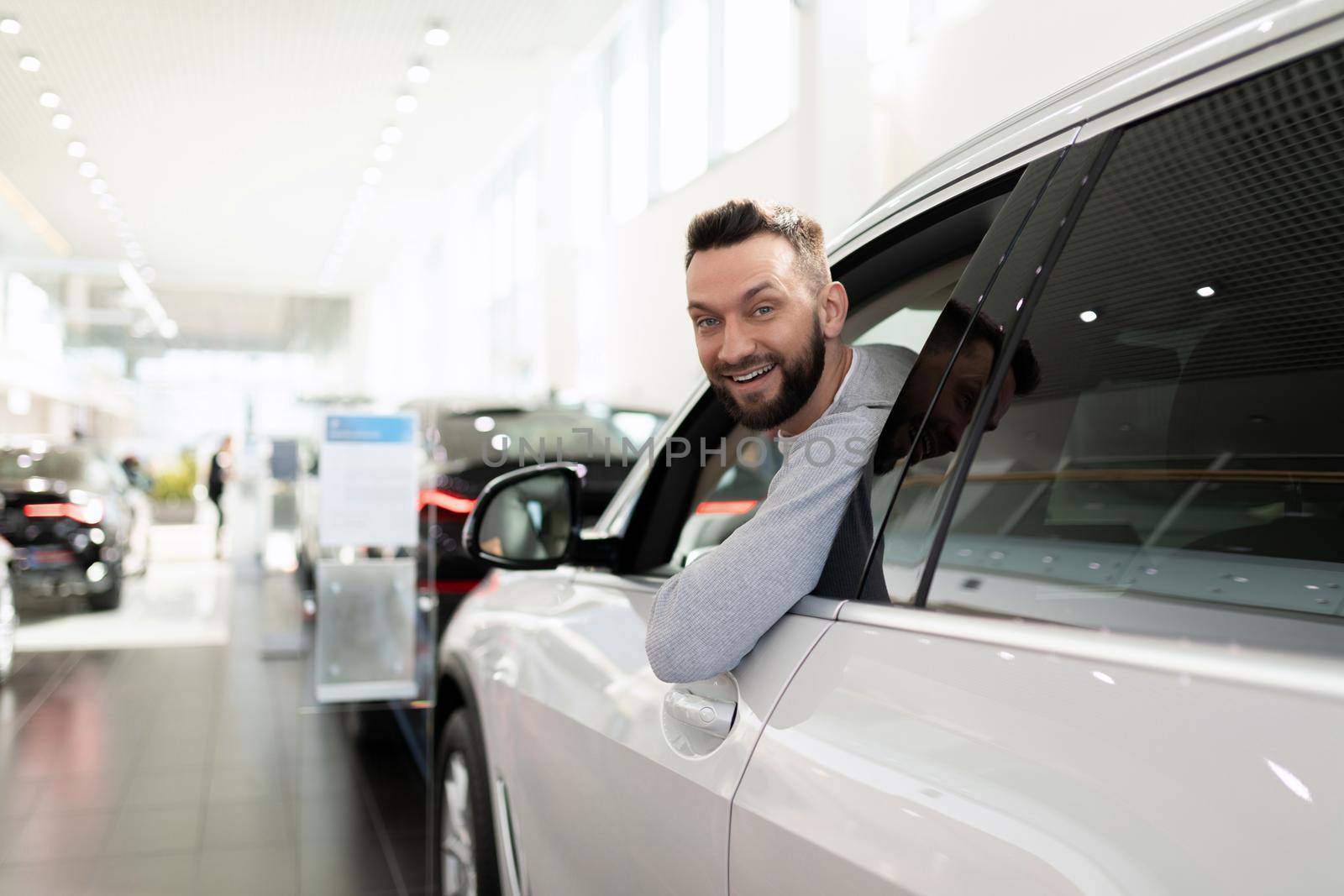 sales manager in a car dealership hands over the keys and documents to the car.
