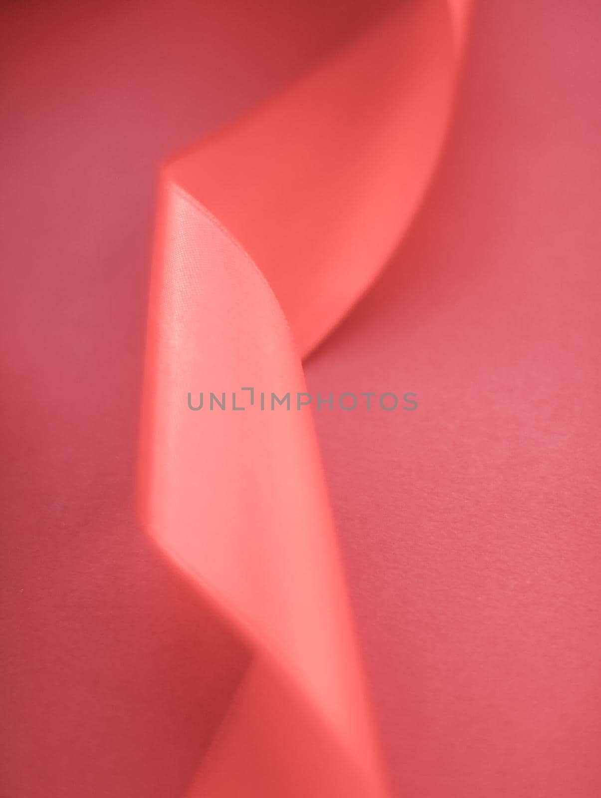 Branding, holidays and luxe brands concept - Abstract curly silk ribbon on coral background, exclusive luxury brand design for holiday sale product promotion and glamour art invitation card backdrop