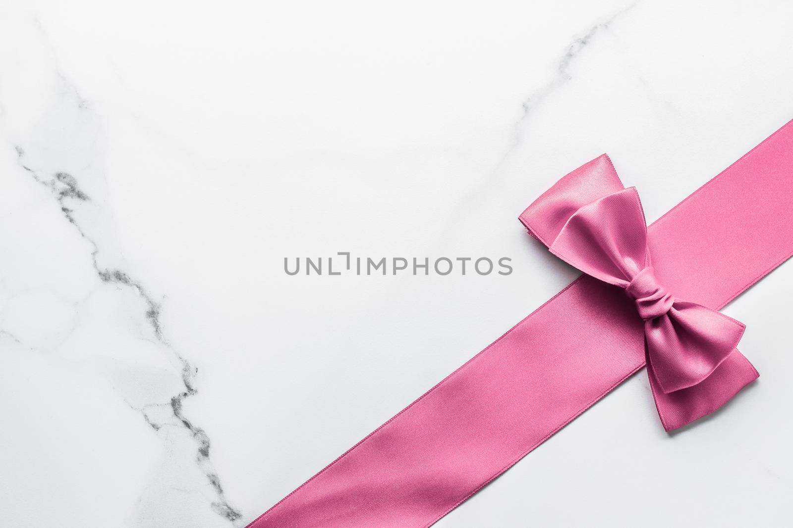 Birthday, wedding and girly branding concept - Pink silk ribbon and bow on marble background, girl baby shower present and glamour fashion gift decor for luxury beauty brand, holiday flatlay design