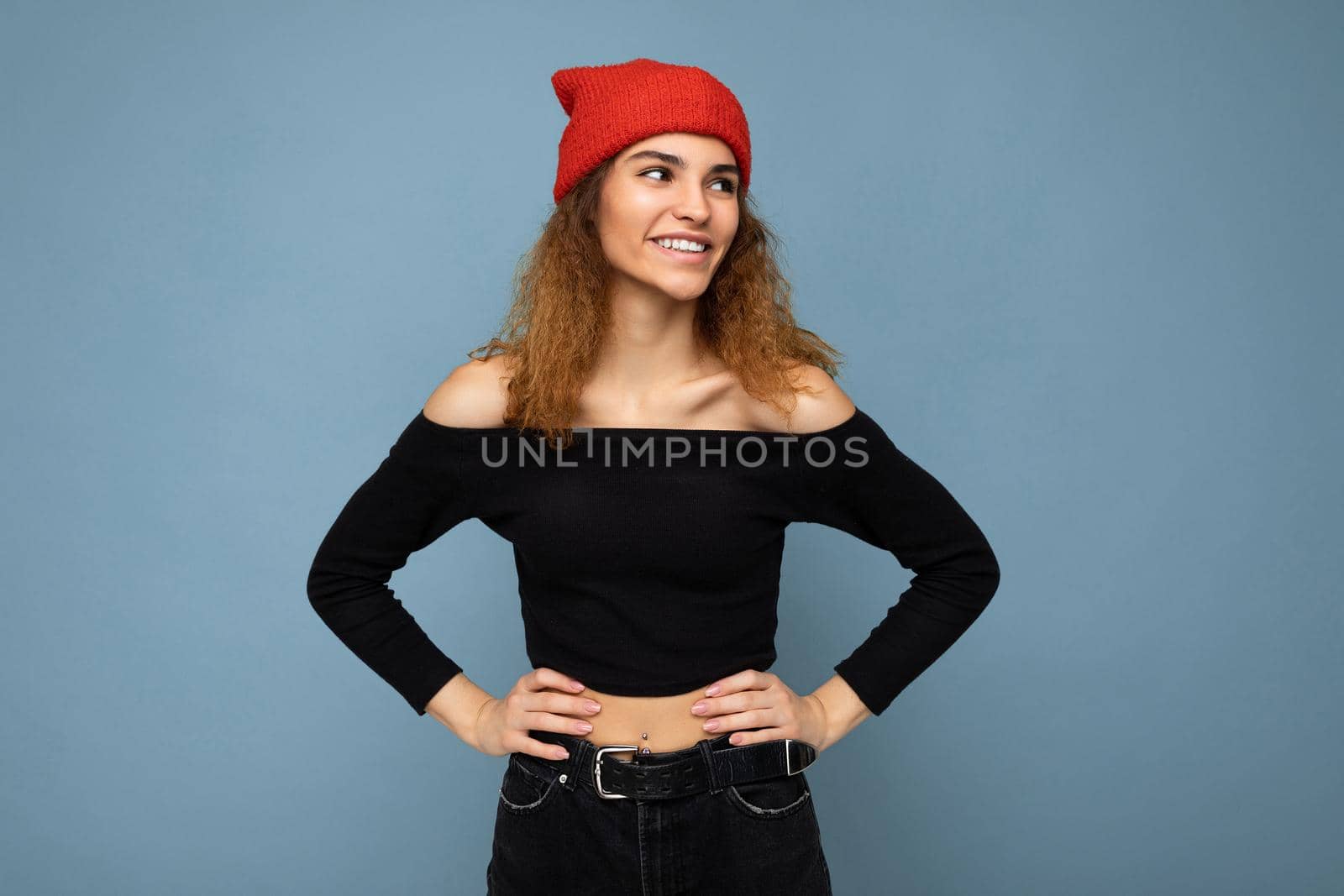 Beautiful smiling happy young brunette woman isolated over blue background wall wearing casual stylish clothes feeling sincere emotions looking to the side.