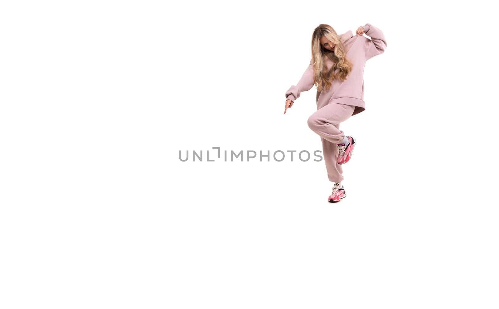 girl in a pink sports suit jumping on a white background.