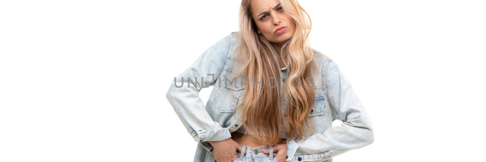 stylish young woman in denim suit fooling around on background without looking at camera.