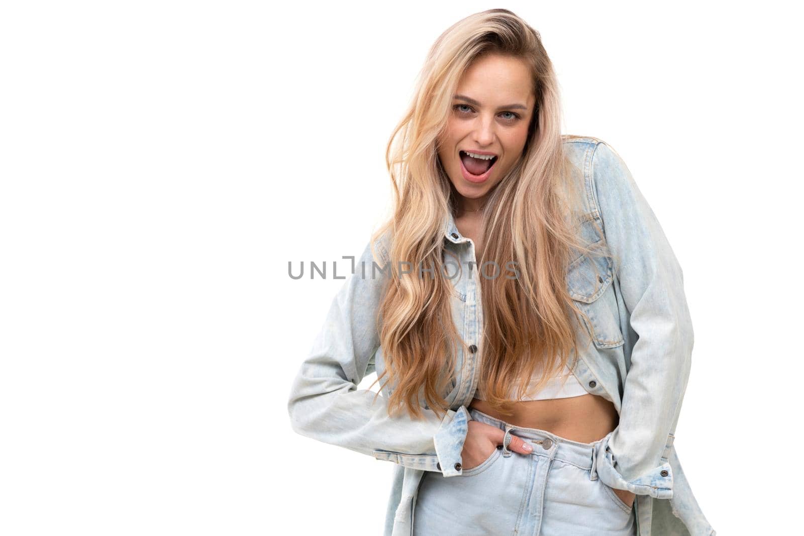 cheerful blonde on a white background with open mouth smiles and looks at the camera.