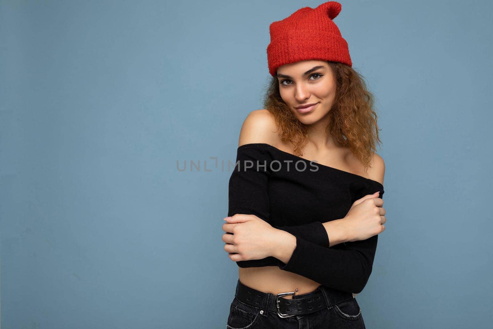 Attractive smiling happy young dark blonde woman standing isolated over colorful background wall wearing everyday stylish outfit showing facial emotions looking at camera. Empty space, copy space