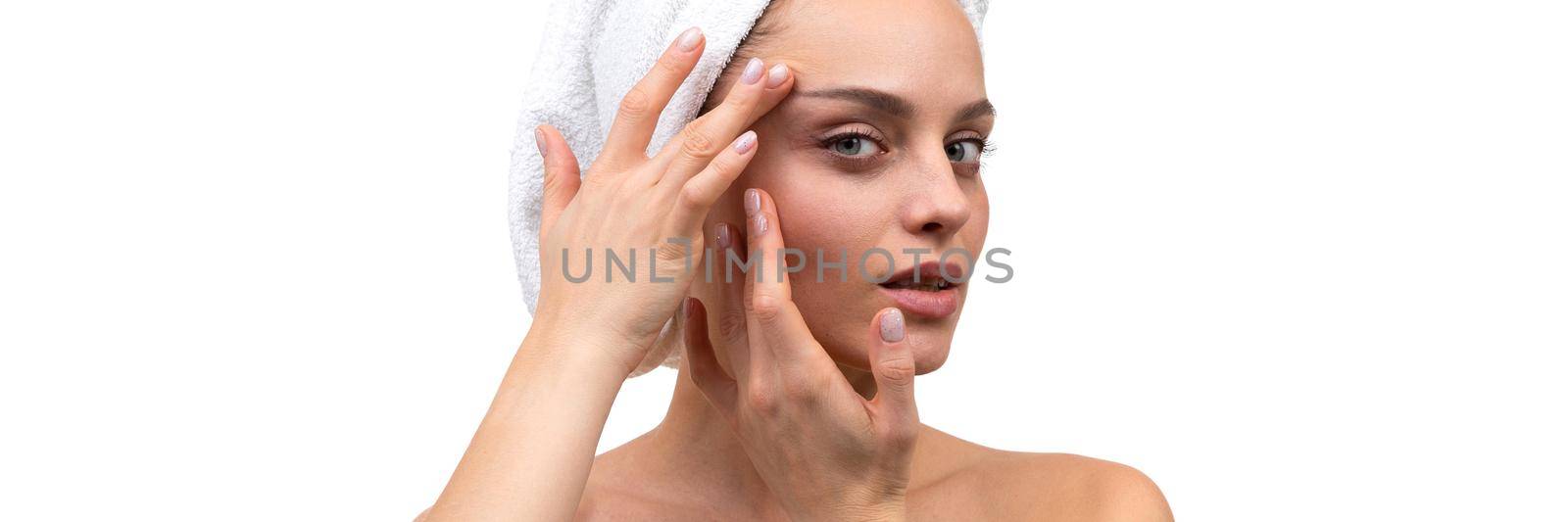 young woman after spa treatments examines her face for wrinkles.