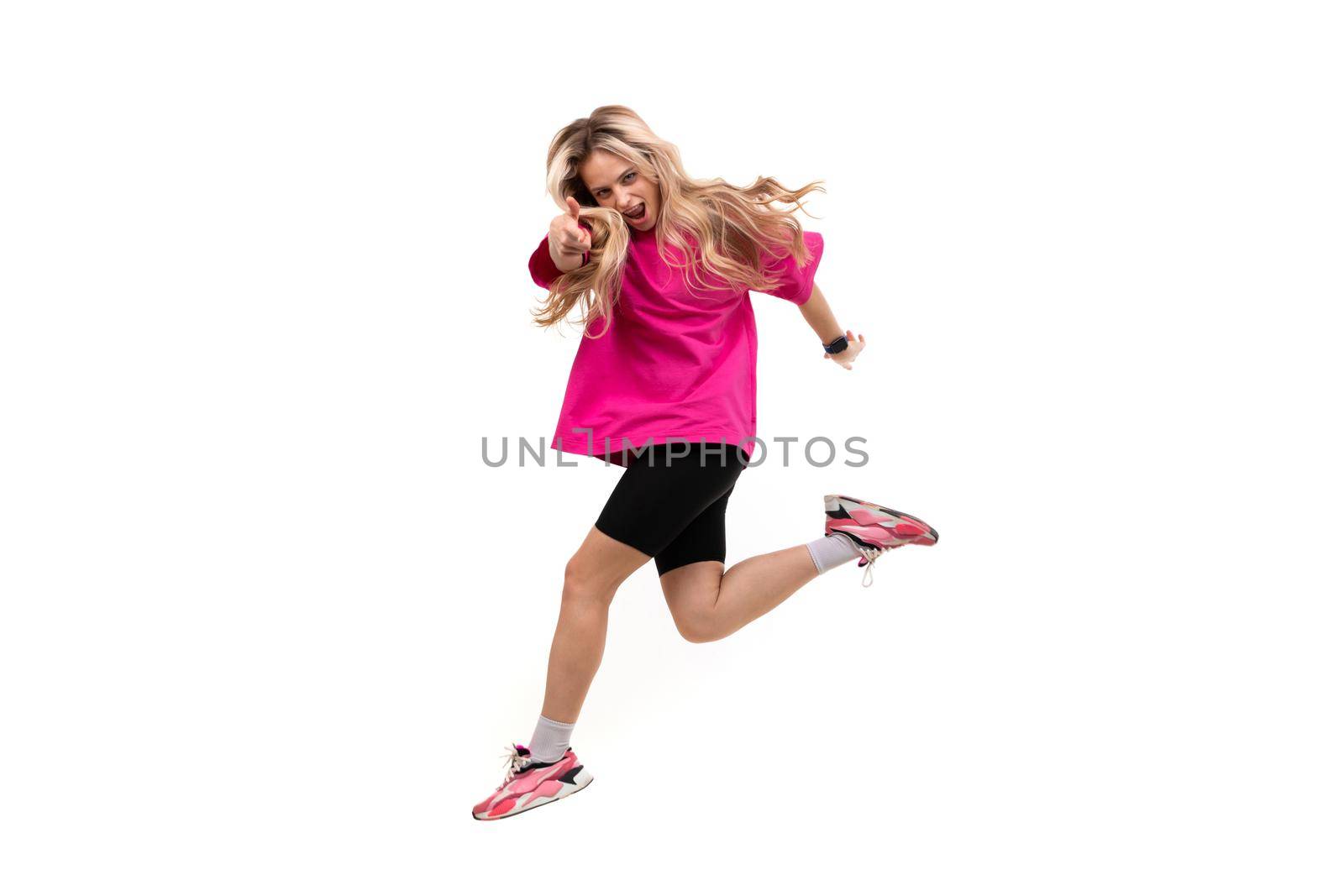young cheerful woman in a jump on a white isolated background shows a forward gesture.