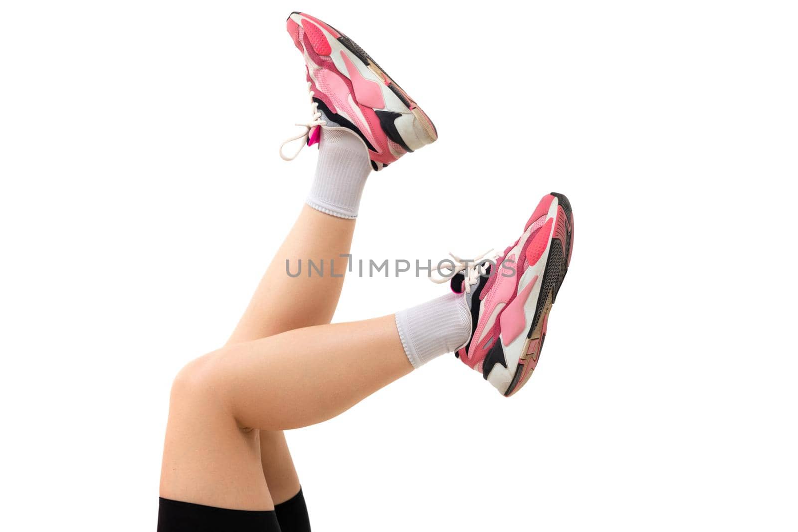 legs of a young athletic woman in pink red running shoes.