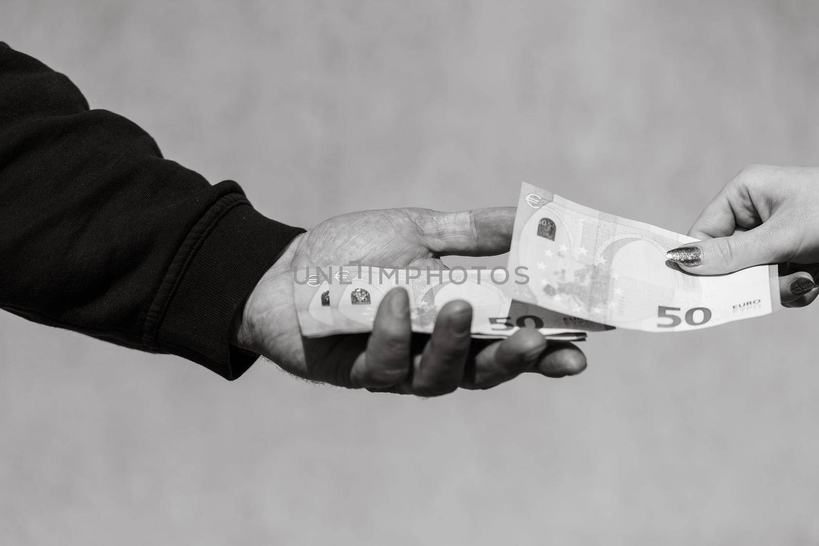 Hand giving money like bribe or tips or salary isolated, hard worked hand taking euro banknotes. Currency transfer and reward for hard work.