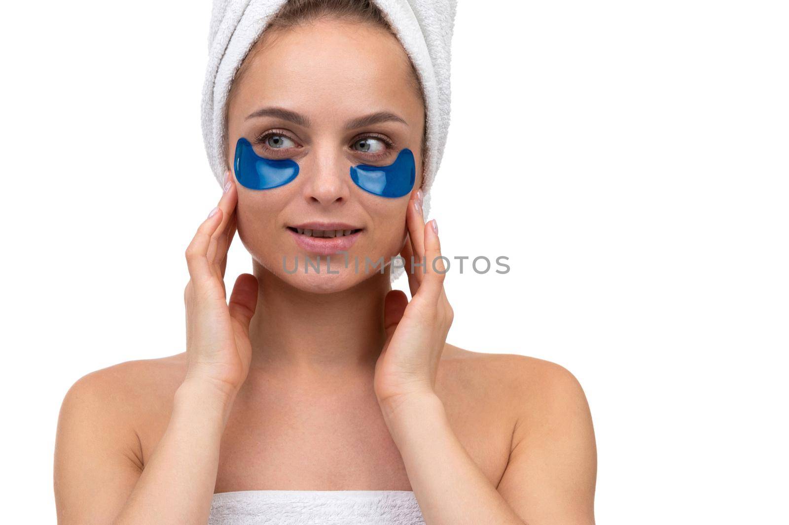 close-up portrait of young woman with cosmetic patches on her face to eliminate bags under eyes.