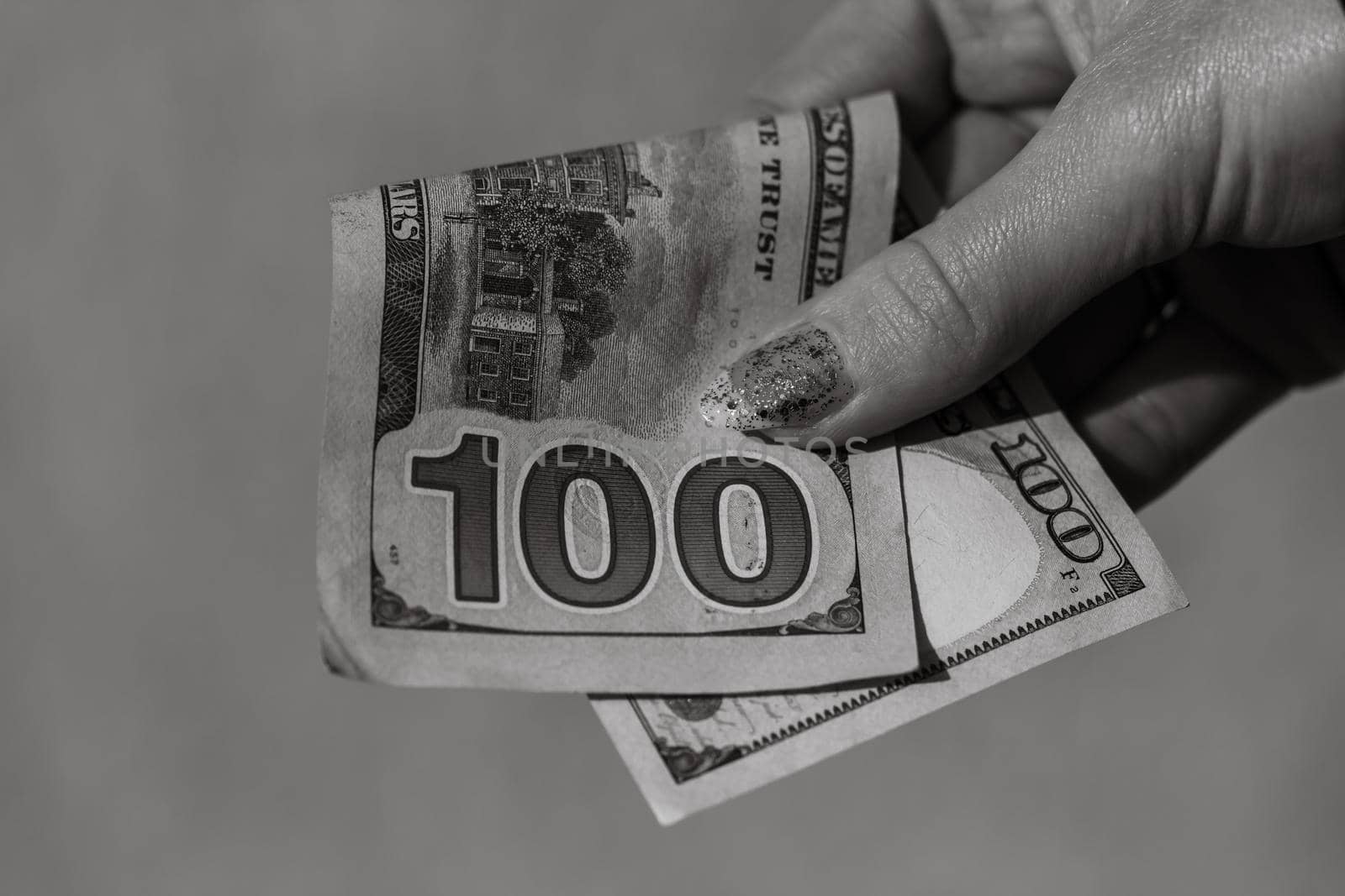 Hands giving money like a bribe or tips. Holding US dollars banknotes on a blurred background, US currency