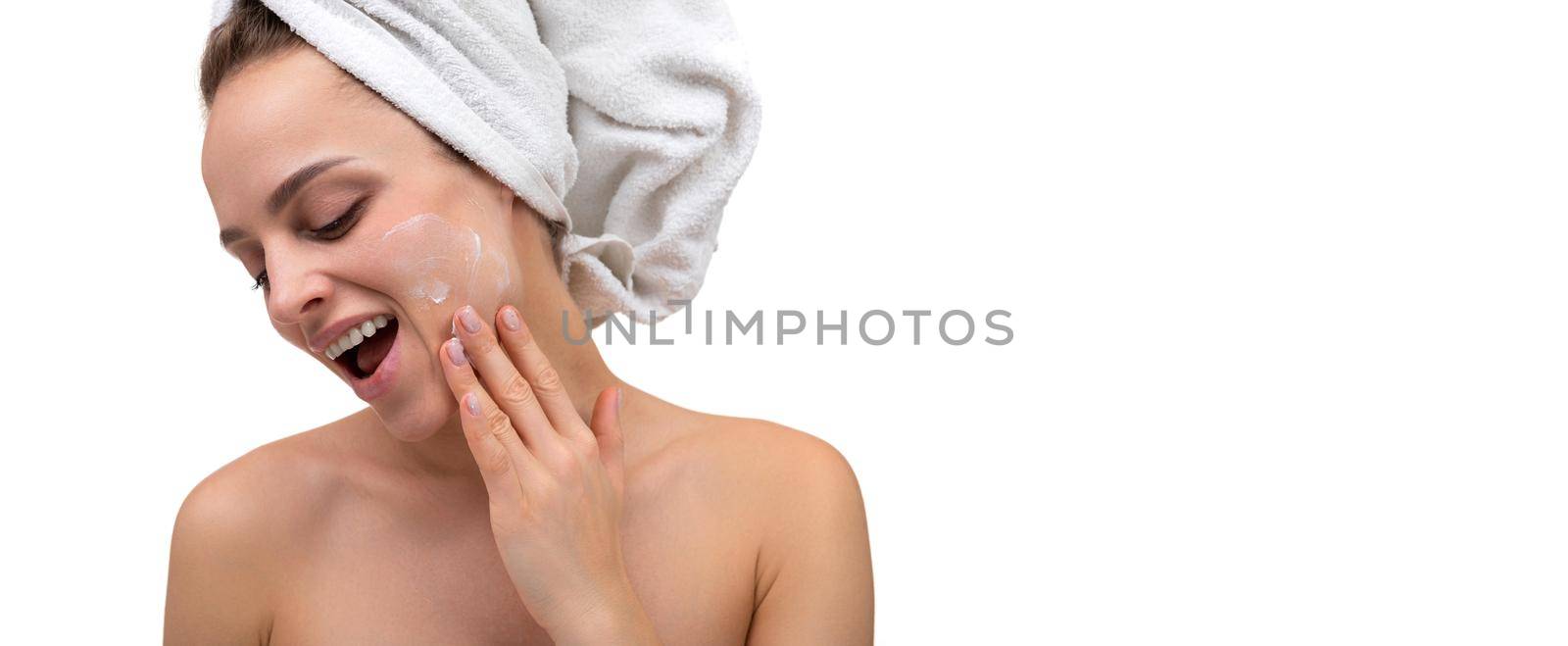 cheerful woman after shower applying cream on her face skin care cosmetic procedures.