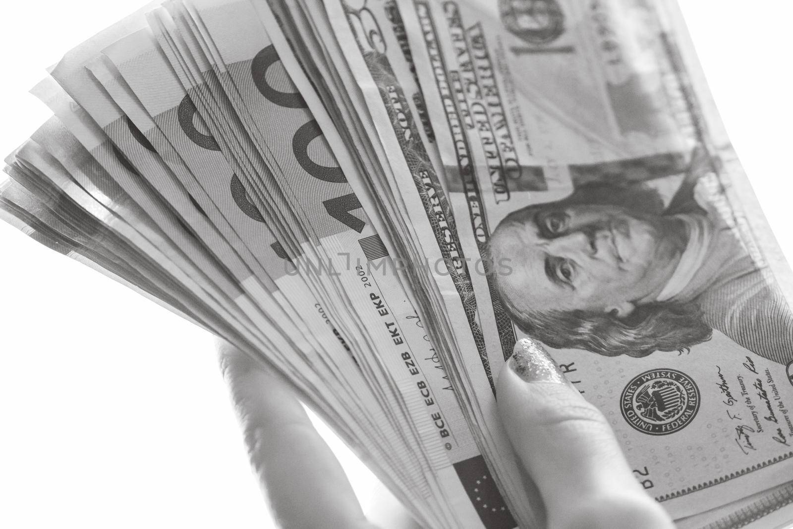 Woman hand giving money like bribe or tips isolated on white background. EURO and USD currency banknotes close up. Reward for hard work, inflation, finance and business concept