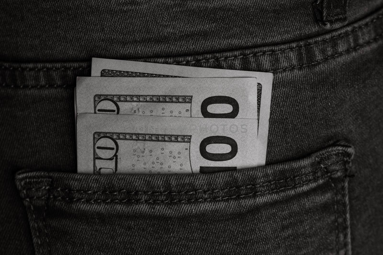 Banknotes close up, money in a jeans pocket. Dollars stick out of the jeans pocket, finance and currency concept. Concept of saving or spending money by vladispas
