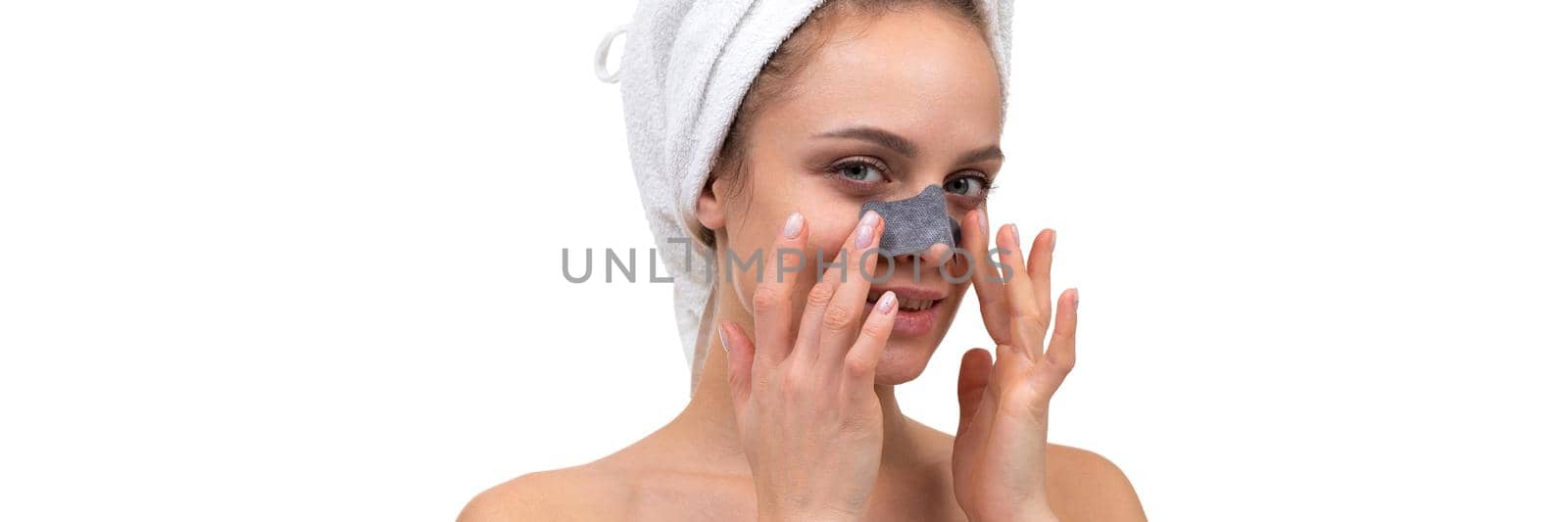 close-up portrait of a woman removing blackheads on the nose with a special cosmetic mask for skin care by TRMK