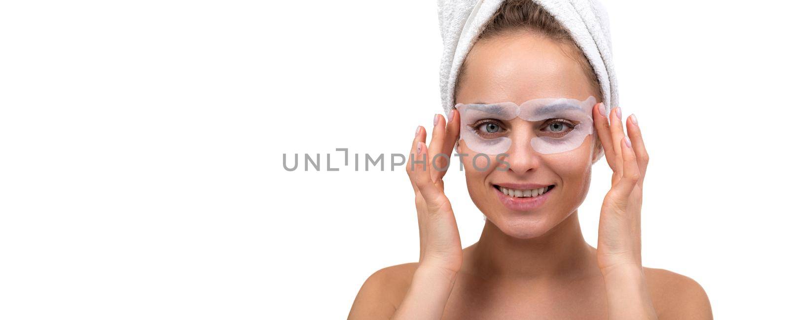 woman with cosmetic patches around eyes after shower on white background.