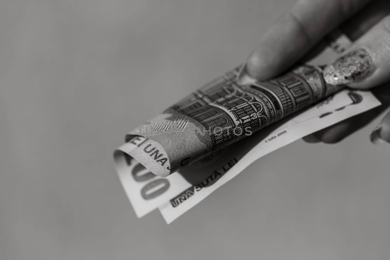 Woman hand giving money like bribe or tips isolated on white background. LEI currency banknotes close up. Reward for hard work, finance and business concept