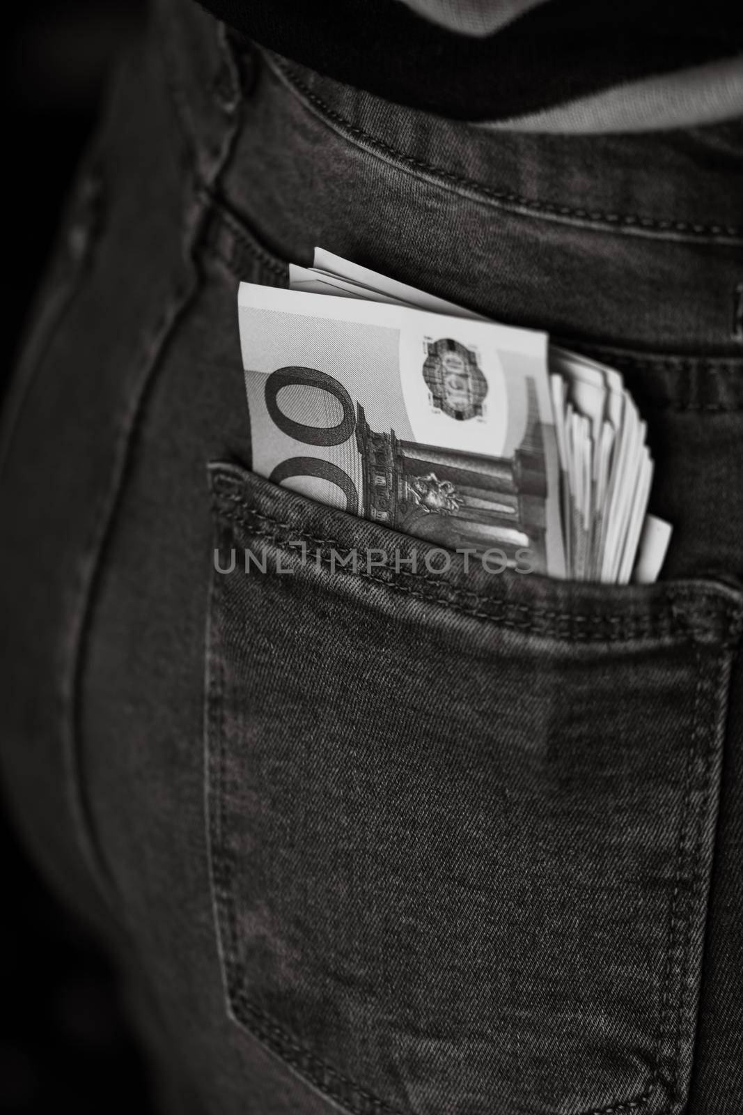 Banknotes close up, money in a jeans pocket. EURO stick out of the jeans pocket, finance and currency concept. Concept of saving or spending money by vladispas