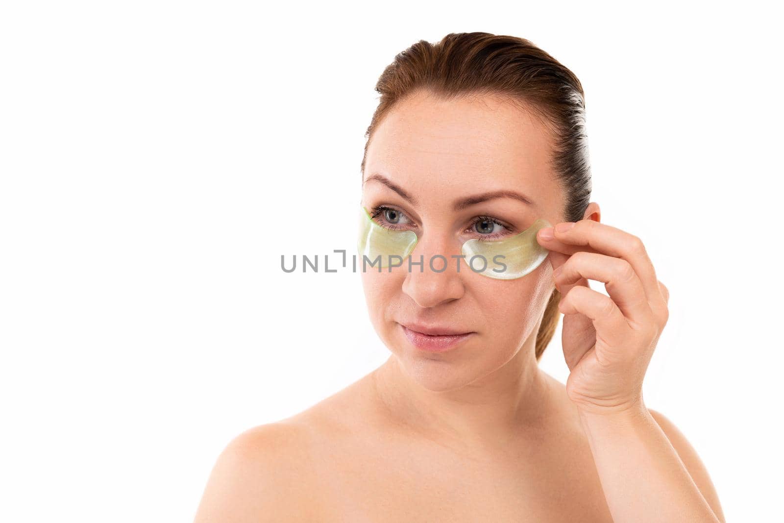 young woman on with cosmetic patches under her eyes.