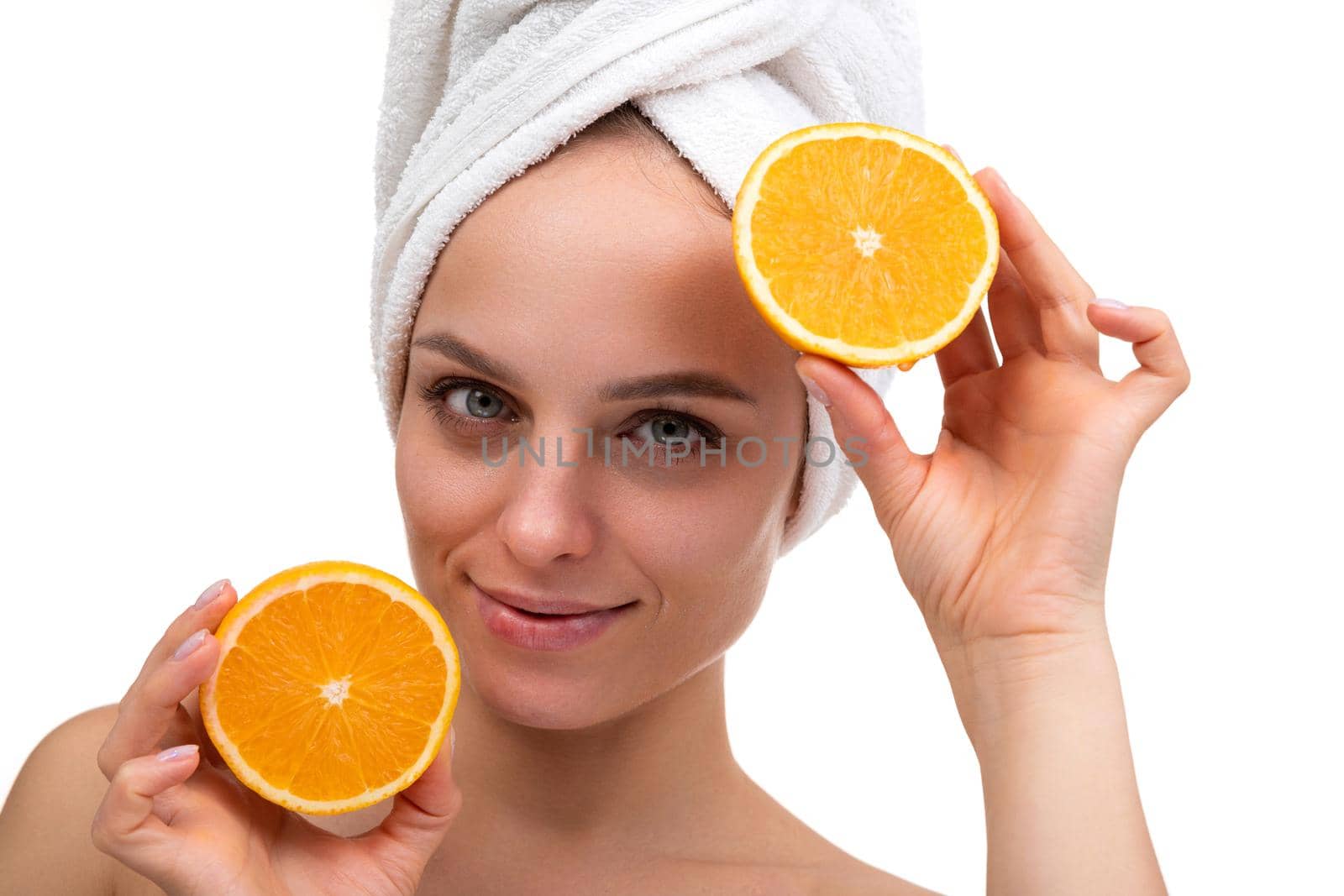 beautiful woman after shower with a cut orange in her hands skin care concept.