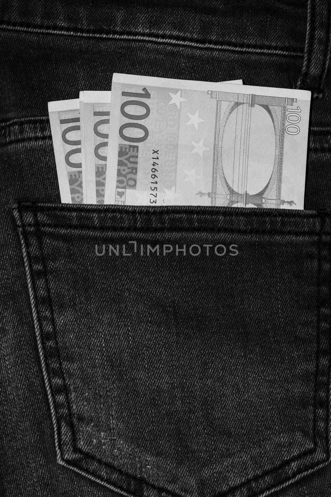 Banknotes, money in a jeans pocket, close up. Money stick out of the jeans pocket, finance and currency concept. Concept of rich people, saving or spending money.