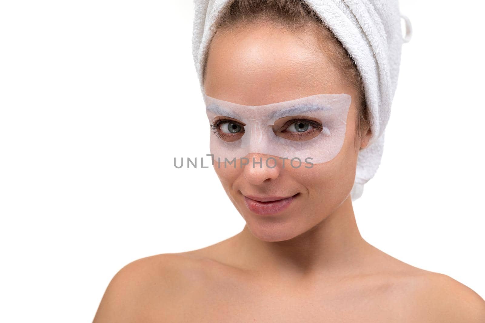 attractive woman on with with a fabric cosmetic mask for skin care around the eyes.