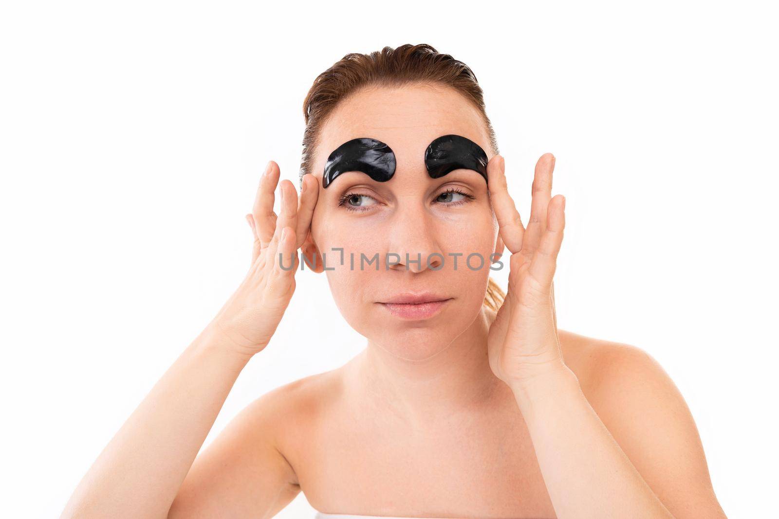 young woman fooling around sticking cosmetic patches on her eyebrows during cosmetic procedures.