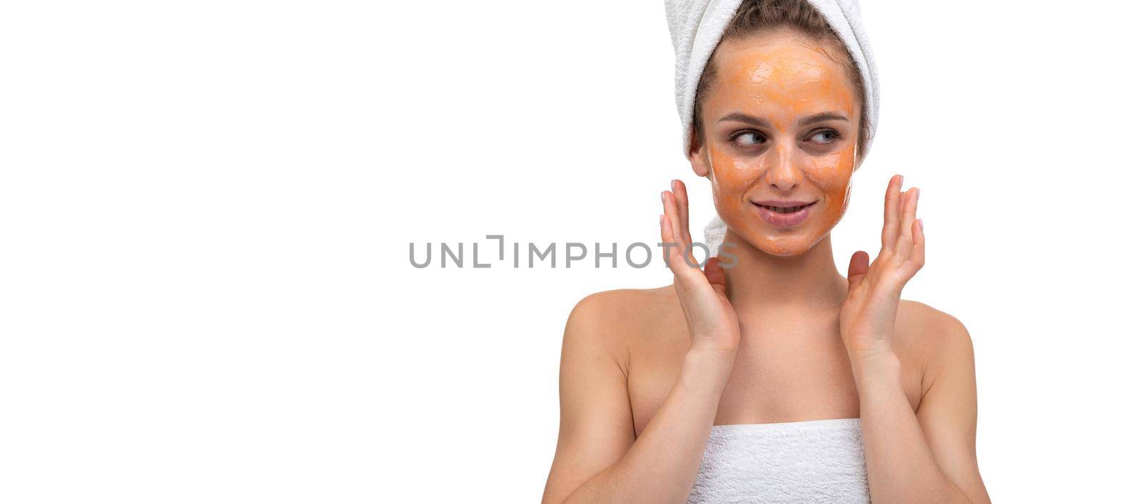 young beautiful woman with cosmetic mask and orange color scrub on her face.