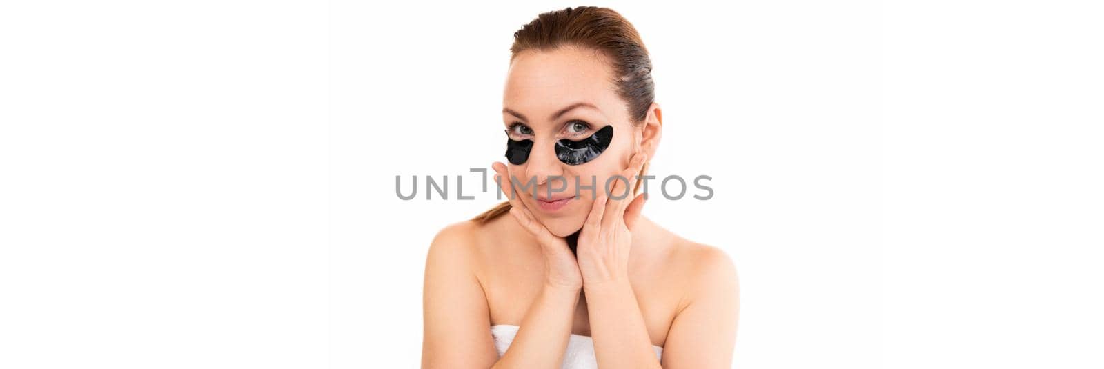 young woman after spa treatments with black cosmetic patches from bags under the eyes.