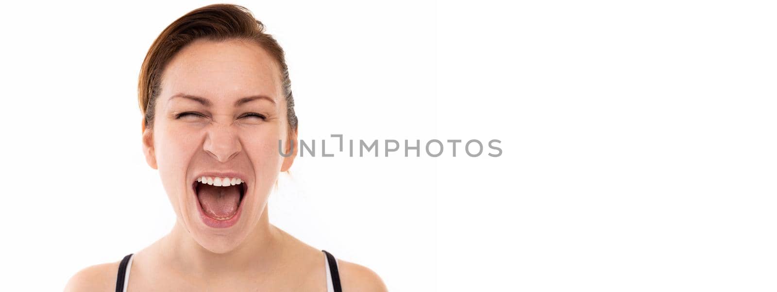 young woman smiling with teeth screaming loudly with her mouth wide open.