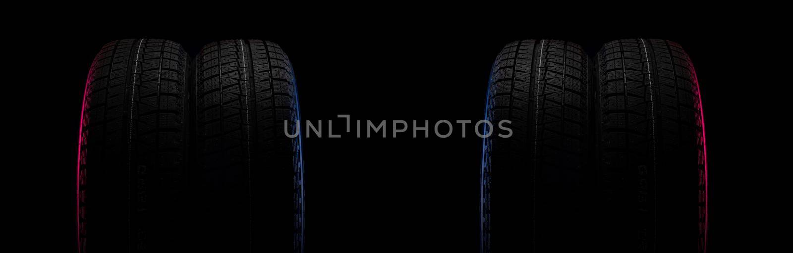 two black tires on a black background with a tread for driving on snow.
