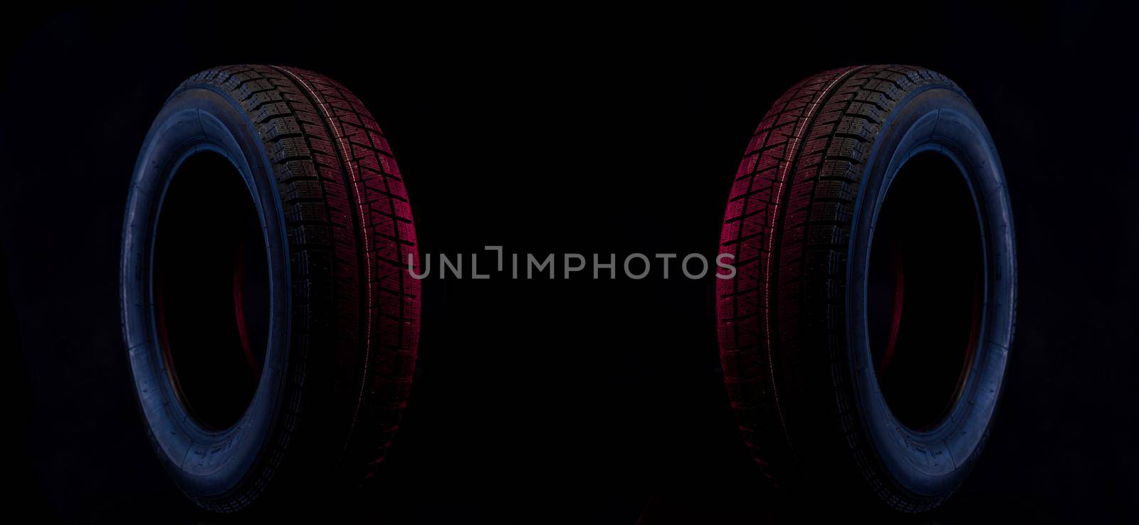 winter wheel for a car on a stylish black and blue red background.