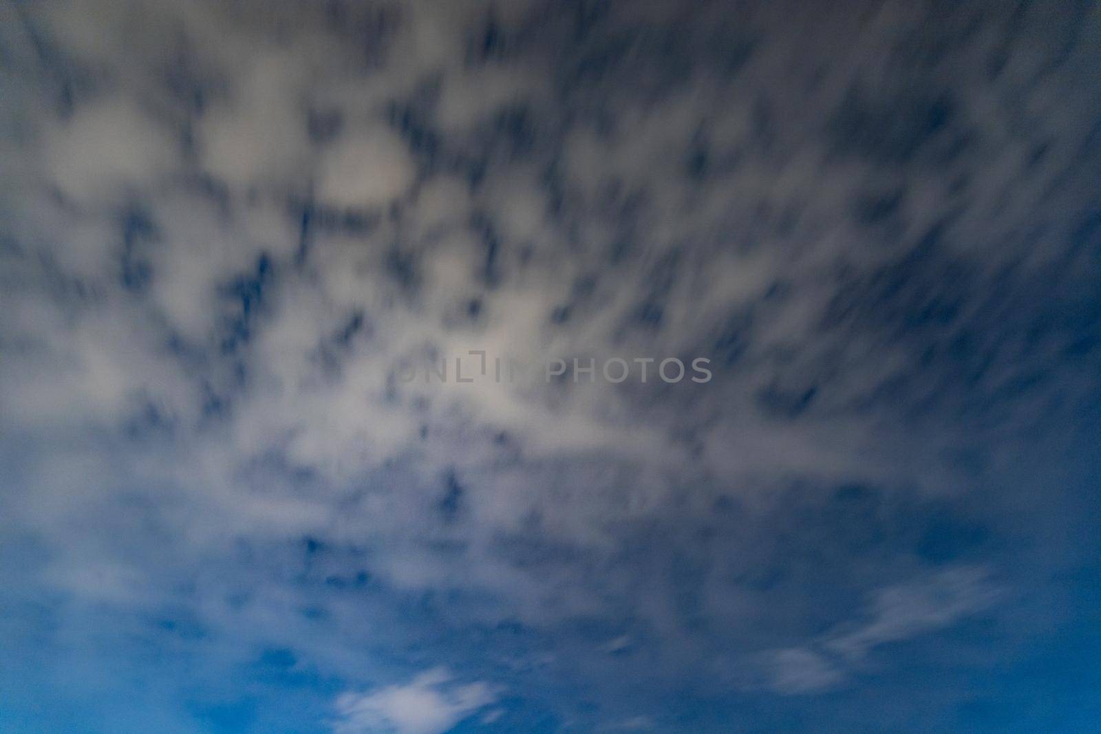 Dark blue sky on long exposure with moving clouds at night 