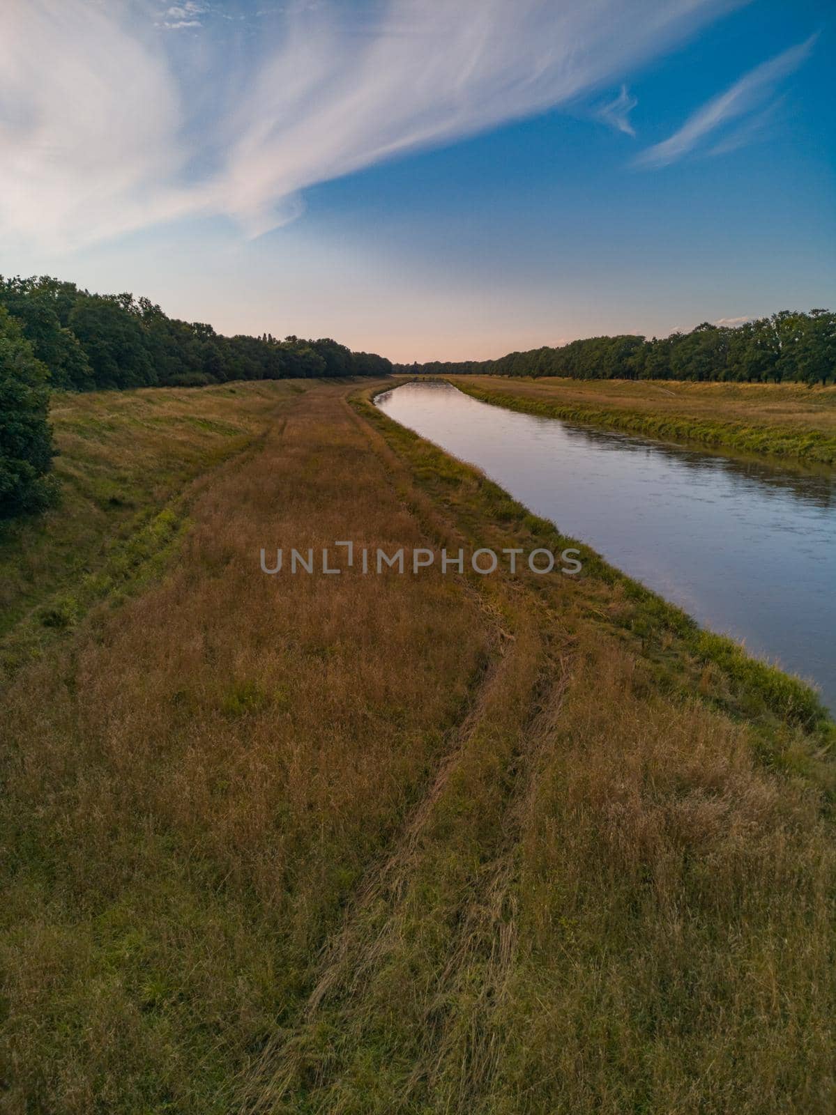 Beautiful colorful landscape of long field between forest and long Odra river by Wierzchu