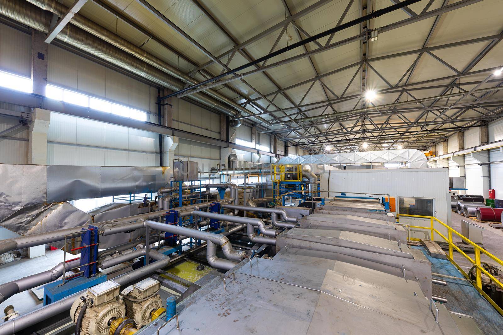 Production line of metal tile for roof. Steel forming machine in metalwork factory workshop.