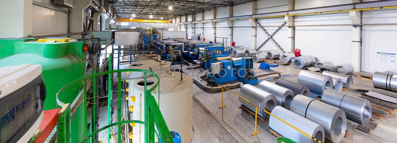 Panoramic photo shot. Steel roofing forming machine. Industrial machine for metal sheet roof coils cut. Process of making steel tile for roof by TRMK