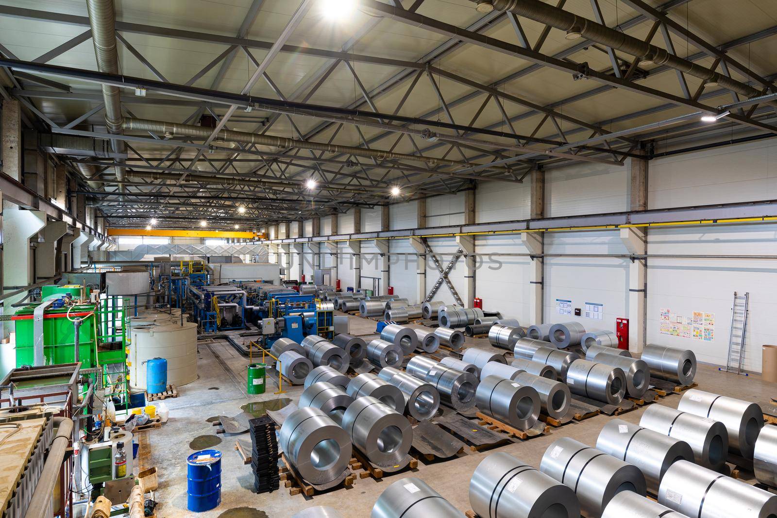 Photo of production line of metal tile for roof. Steel forming machine in metalwork factory workshop by TRMK