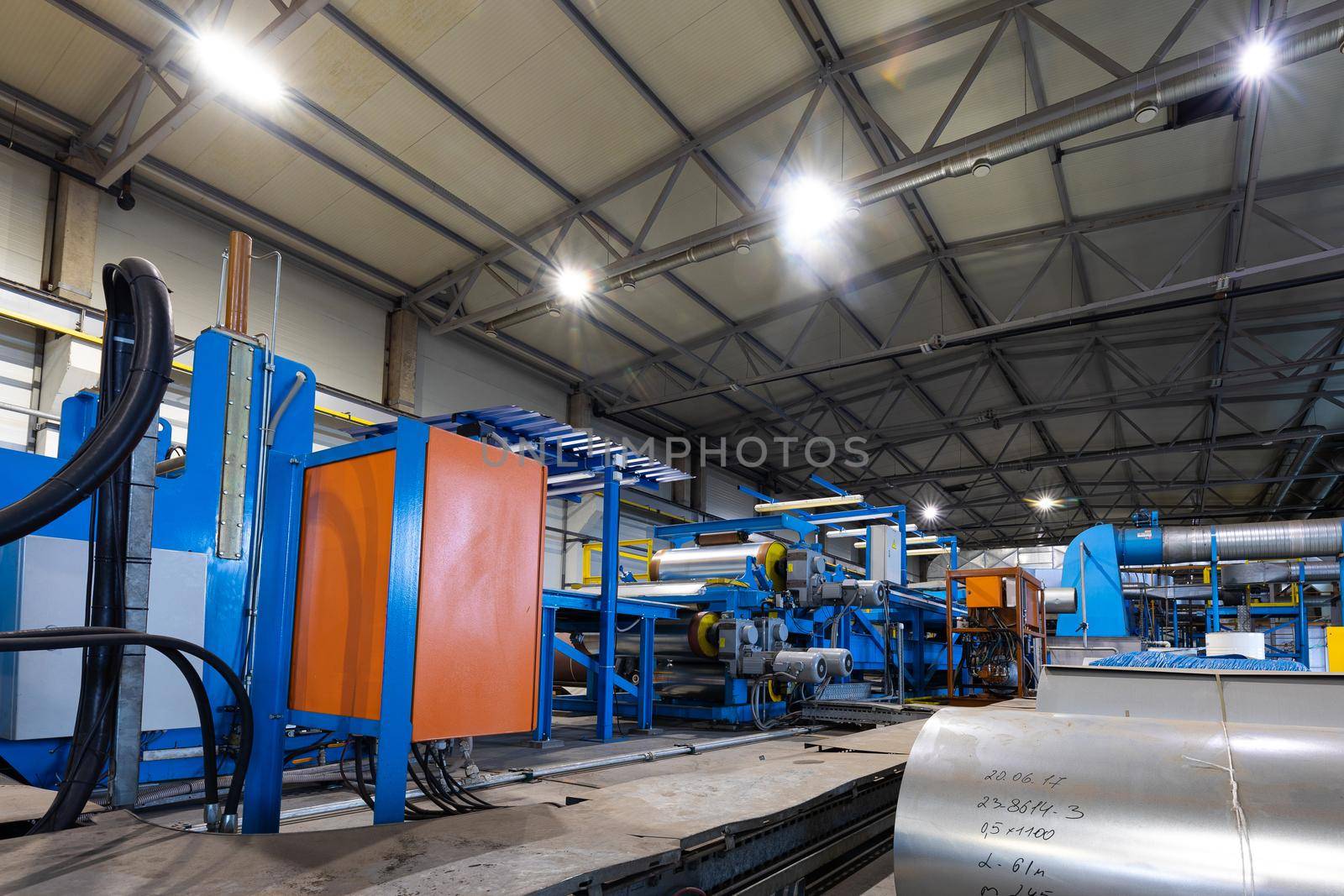 Production line of metal tile for roof. Steel forming machine in metalwork factory workshop. Metal sheet profiling machine.