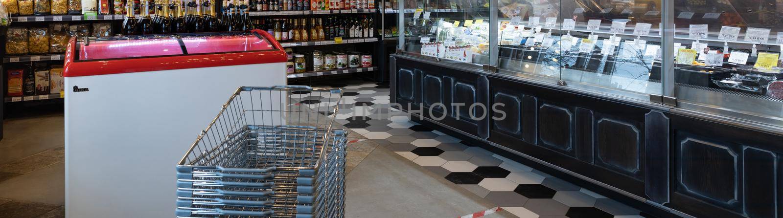 Minsk, Belarus - Dec 20, 2021: interior of a small cozy store with a large refrigerated display case and shelves on the wall by TRMK