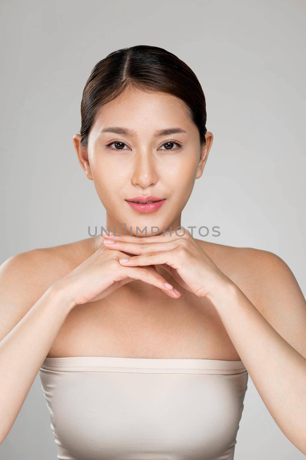 Portrait of ardent young woman with healthy clear skin and soft makeup looking at camera and posing beauty gesture. Cosmetology skincare and beauty concept.