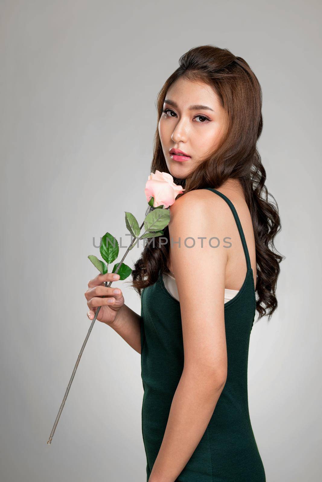 Ardent female model with fair skin and perfect makeup holding flowers. by biancoblue