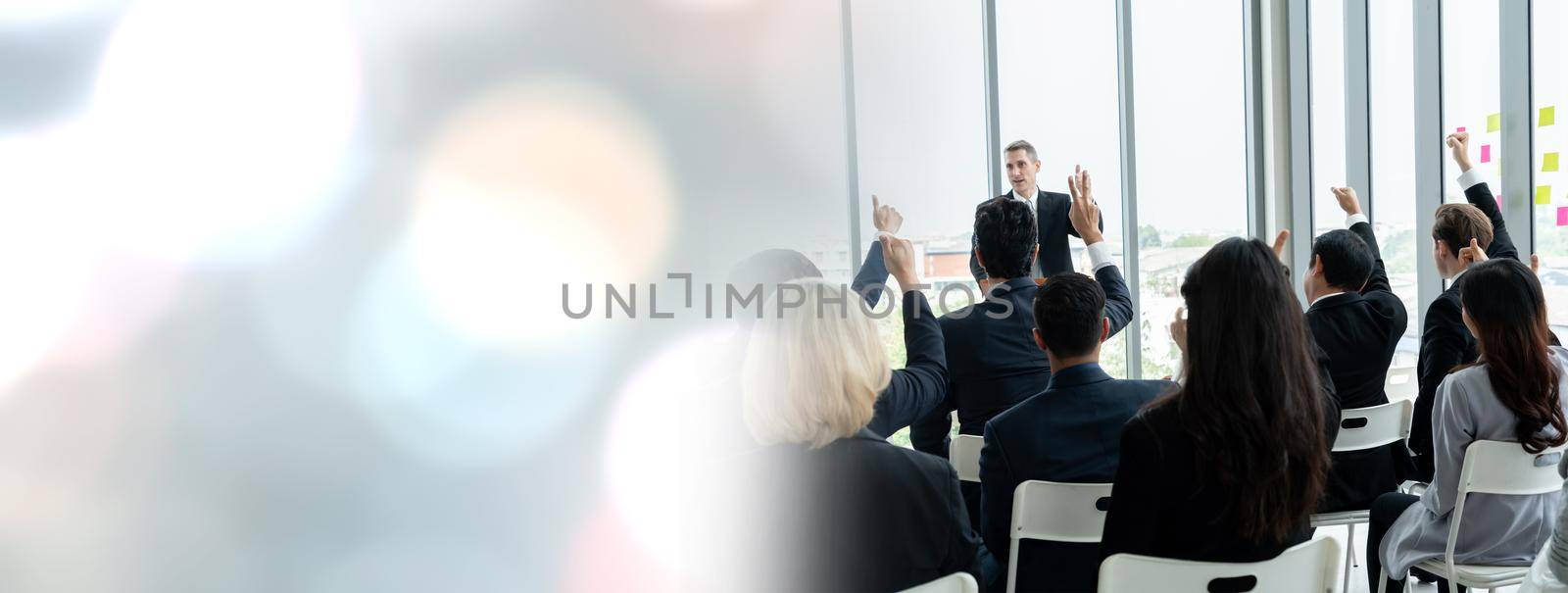 Group of business people meeting in a seminar conference widen view . Audience listening to instructor in employee education training session . Office worker community summit forum with speaker .